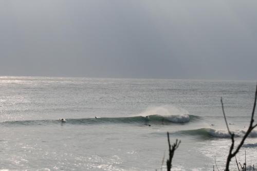 a group of surfers riding a wave in the ocean at Donghe surf shop & Hostel in Donghe