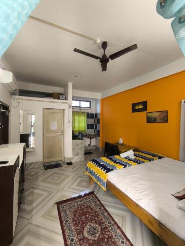 two beds in a room with orange walls at Purabi's Nest in Tezpur