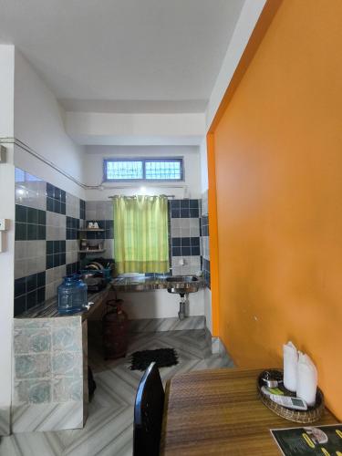 a kitchen with a sink and a table in a room at Purabi's Nest in Tezpur