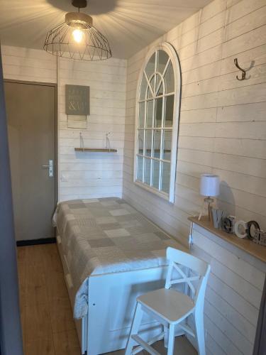 - une chambre avec un lit et deux chaises dans l'établissement Magnifique Studio Cassis, à Cassis