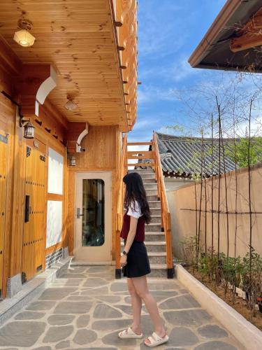 a woman walking down a porch of a house at 경주 황리단길 한옥스테이 다가감 in Gyeongju