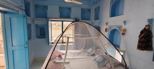 a small room with a bed with a canopy at Hotel Bharatpur Palace in Pushkar