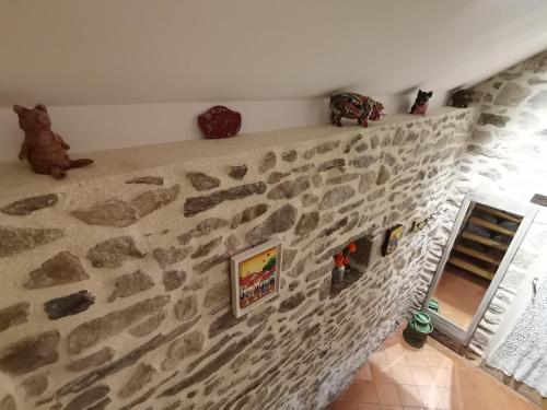 a stone wall with some figurines on top of it at La petite porcherie in Ladignac-le-Long