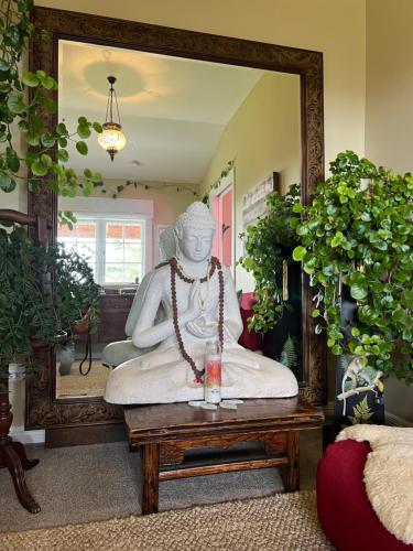 a statue sitting on a table in front of a mirror at Fridas Accommodation in Raglan