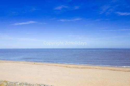 a sandy beach with the ocean in the background at Lovely Caravan With Large Decking And Wi-Fi In Norfolk Ref 50053K in Great Yarmouth