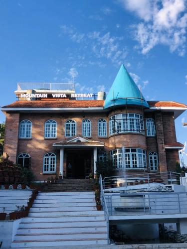 a large brick building with a blue roof at Mountain Vista Retreat in Nagarkot
