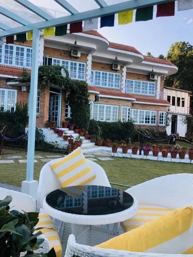 a patio with chairs and a table and a building at Mountain Vista Retreat in Nagarkot