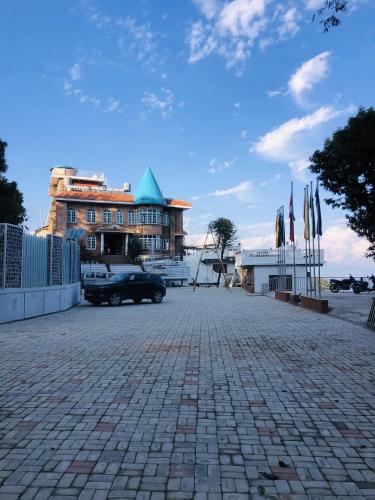 a car parked in front of a building with flags at Mountain Vista Retreat in Nagarkot