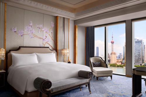 a bedroom with a bed and a chair and a window at The St. Regis on the Bund, Shanghai in Shanghai