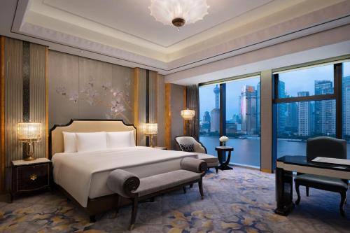 a bedroom with a bed and a desk and a window at The St. Regis on the Bund, Shanghai in Shanghai