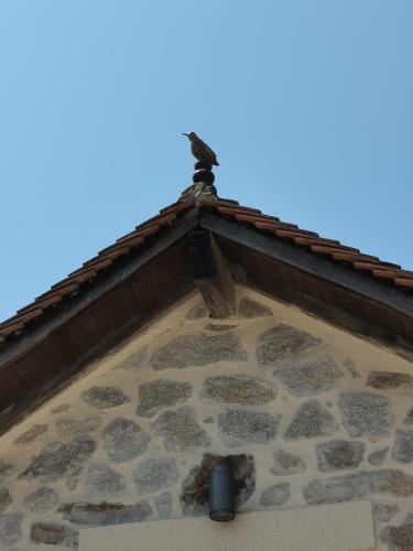 a roof of a building with a bird on top at La petite porcherie in Ladignac-le-Long
