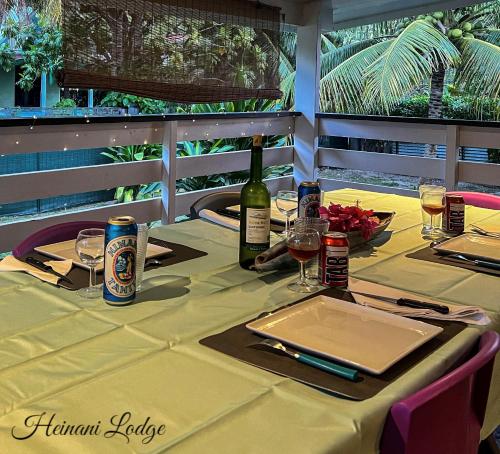 a table with a bottle of wine and glasses at Heinani Lodge Tiahura in Moorea