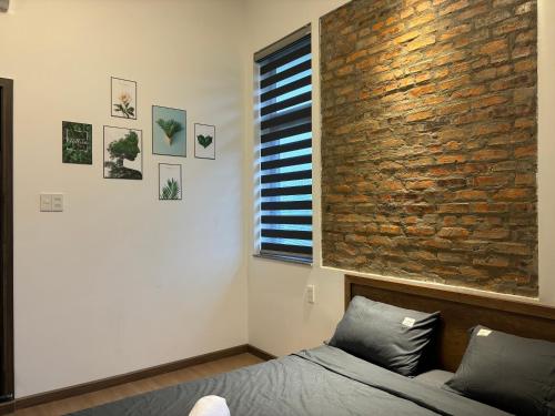 a bedroom with a brick wall and a bed at Lucky coffee & homestay in Thôn Trường Giang