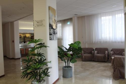 a lobby with two potted plants and a couch at Hotel Palace Masoanri's in Reggio Calabria