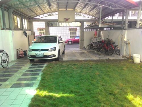 a car parked inside of a garage with bikes at Wooden Man Homestay in Taitung City