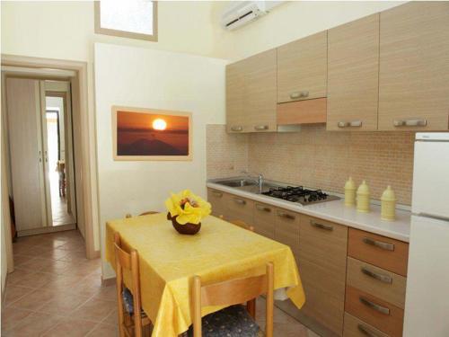 a kitchen with a table with yellow flowers on it at Blu Tropical Resort in Zambrone
