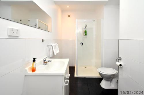 3 Bedroom 2 Bathroom Heathfield Avenue Salamanca 50m في هوبارت: حمام أبيض مع حوض ومرحاض