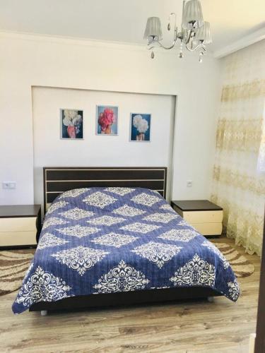 a bedroom with a blue and white quilt on a bed at Дом в Боровом in Borovoye