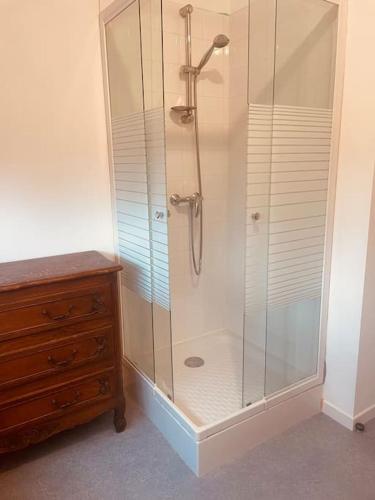 une douche avec cabine de douche en verre à côté d'une commode dans l'établissement Appartement 200m de la plage, à Hauteville-sur-Mer