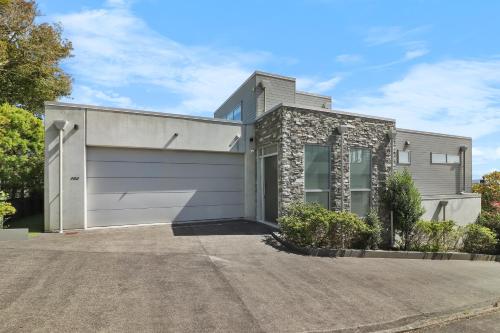 a house with a garage at Orakei Oasis l Quality 3 Bed House inc Views in Auckland