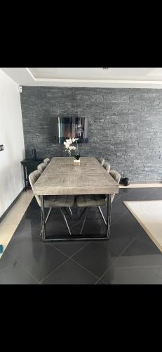 - une table dans une pièce dotée d'un mur en briques dans l'établissement Maison calme avec piscine privée, à Argenteuil