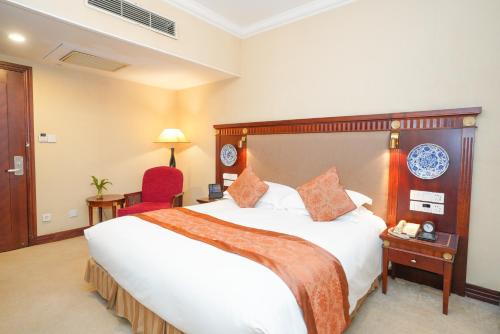 a hotel room with a large bed and a red chair at Broadway Mansions Hotel - On the Bund - Journey Through Time Old Shanghai Republic Dreams in Shanghai