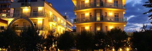 a large building with lights on in front of it at Hotel Lady Mary in Milano Marittima
