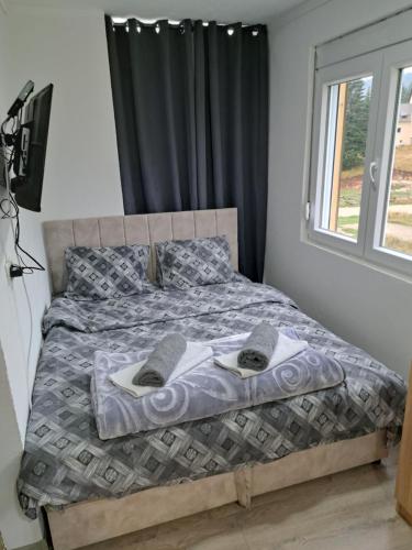 a bedroom with a bed with towels on it at Villa JELENA - Guest House Nela in Žabljak