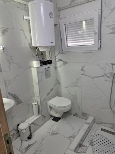 a white bathroom with a toilet and a sink at Villa JELENA - Guest House Nela in Žabljak