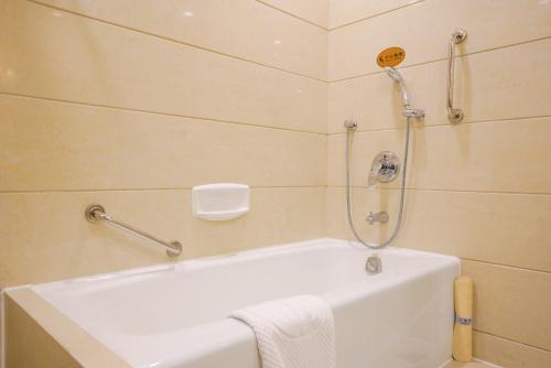 a white bath tub in a bathroom with a shower at Broadway Mansions Hotel - On the Bund - Journey Through Time Old Shanghai Republic Dreams in Shanghai
