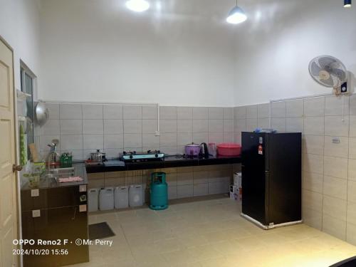 a kitchen with a black refrigerator in a room at SP HOMESTAY Taman SURIA INDAH KOTA MARUDU SABAH in Kampong Sorosob
