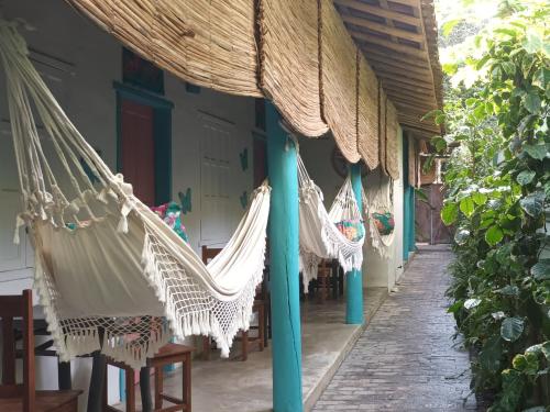 a group of hammocks hanging from a porch at 4eTal Trancoso EXCLUSIVO PARA MULHERES ONLY WOMEN in Trancoso