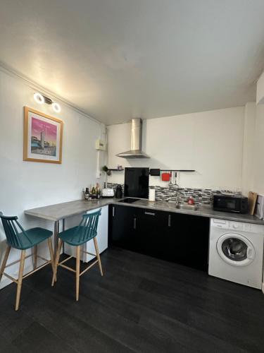 une cuisine avec une table, des chaises et une cuisinière dans l'établissement Studio Prunus Hyper centre, à Lorient