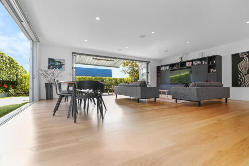 a living room with a table and chairs at Orakei Oasis l Quality 3 Bed House inc Views in Auckland