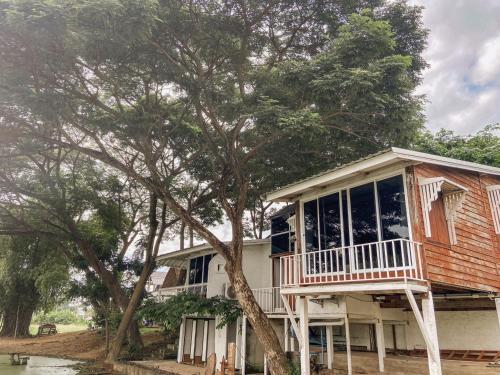 a house with a porch and a tree at The Sun House อุทัยธานี in Ban Nam Tok