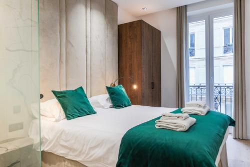 une chambre avec un grand lit avec des oreillers verts dans l'établissement Perfect for exploring - 2BR-6P - Center of Paris, à Paris