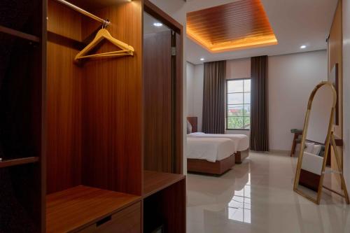 a bedroom with a bed and a closet at Sakanti Inn Wonosobo in Kalibeber