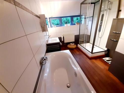 a bathroom with a tub and a glass shower at Nature Circuit Francorchamps in Stavelot