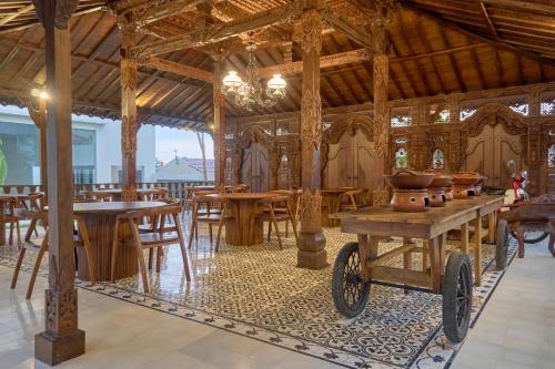 a room with wooden tables and chairs and a cart at Sakanti Inn Wonosobo in Kalibeber