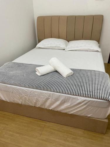 a bed with two white towels on top of it at De'Garden 12 in Alor Setar