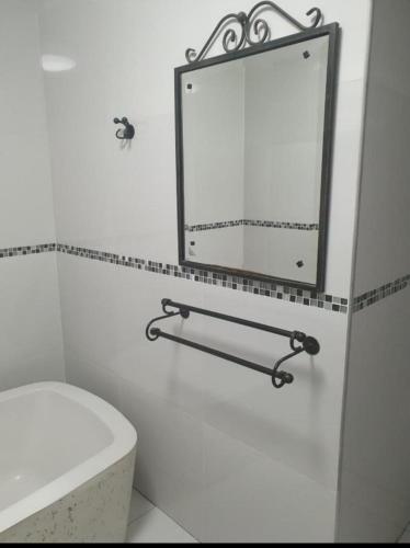 a bathroom with a white toilet and a mirror at Alu Boutique Hotel and Conference in Roodepoort