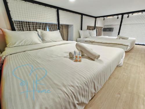 two beds in a room with white sheets at Sunway GRID by SR Home in Kampong Pendas