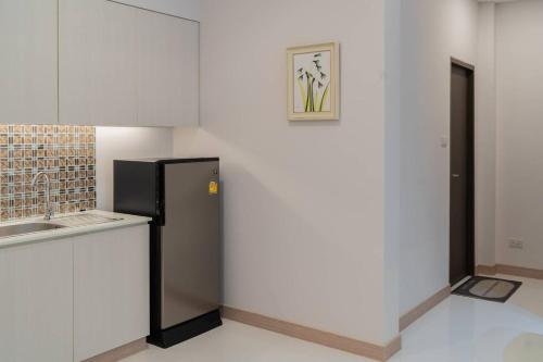 a kitchen with a refrigerator next to a counter at เดอะแรบบิทโฮม รีสอร์ท ระยอง in Pluak Daeng