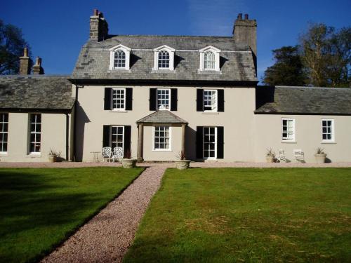 a large white house with a large yard at Tor Royal Farm House in Princetown