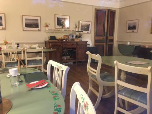 comedor con mesa verde y sillas en Tor Royal Farm House, en Princetown
