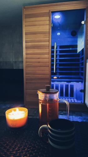 a candle and a pot on a table with a window at StoneMlynska 7 Slovakia in Svit