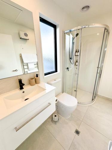 a bathroom with a toilet and a sink and a shower at Cosy Modern Home - New Build in Christchurch in Christchurch