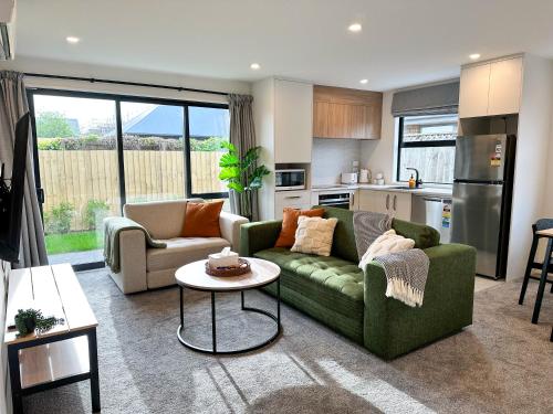 a living room with a couch and a table at Cosy Modern Home - New Build in Christchurch in Christchurch
