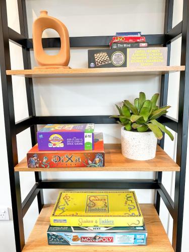 a shelf with books and a pair of scissors at Cosy Modern Home - New Build in Christchurch in Christchurch