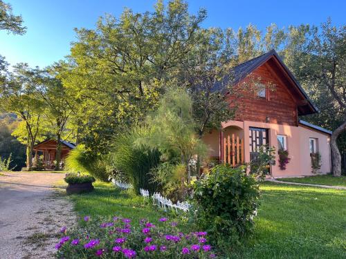 a house with purple flowers in front of a yard at Vacation Home Pliva in Šipovo